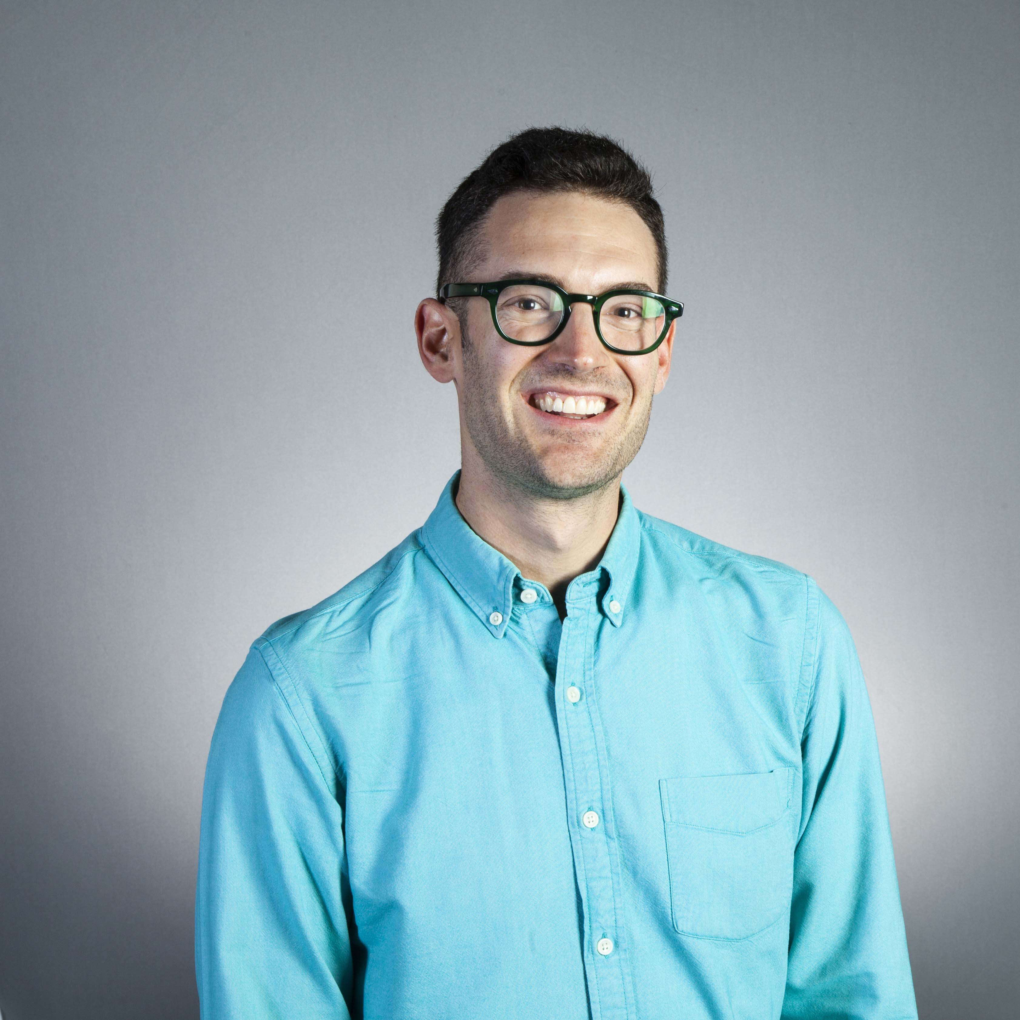 Daniel Field headshot wearing blue shirt and glasses
