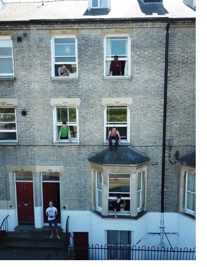 Rory and his housemates looking out of the street-facing windows of two houses owned by Christ's College on Jesus Lane.