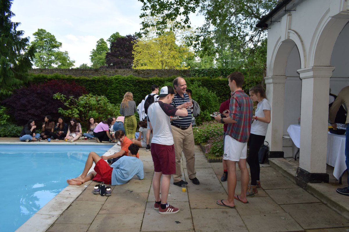 Students and tutors chatting by swimming pool