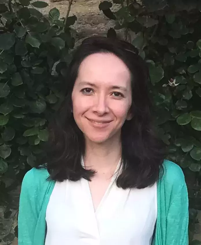Isabel Huang-Doran headshot wearing green cardigan with long dark hair