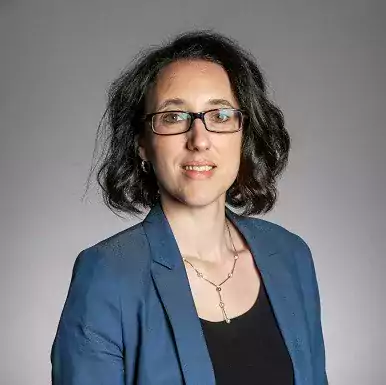 Chiara Giorio headshot wearing blue jacket and glasses