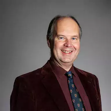 Robert Hunt headshot wearing burgundy shirt and jacket