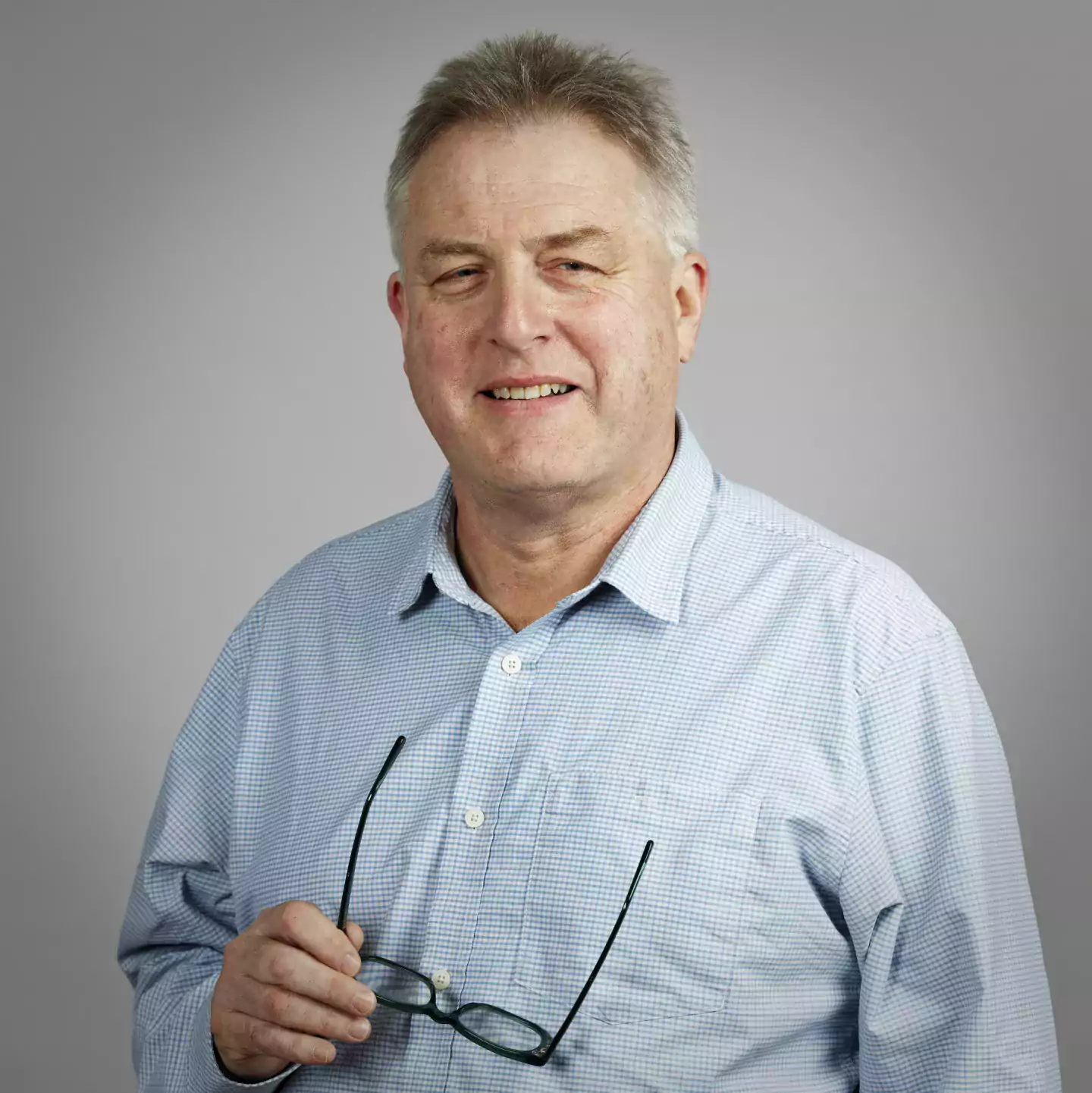 Paul Barker headshot holding glasses