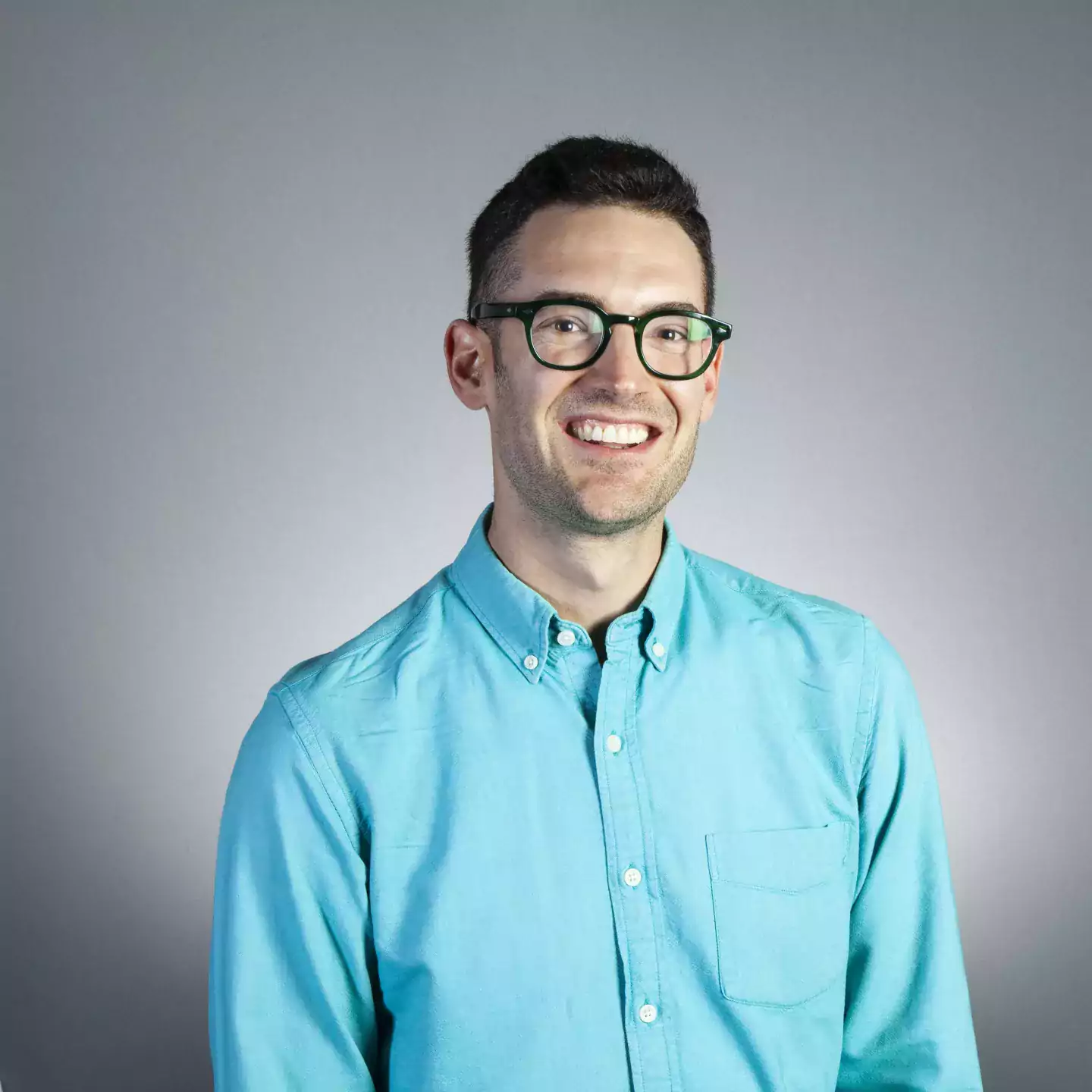 Daniel Field headshot wearing blue shirt and glasses